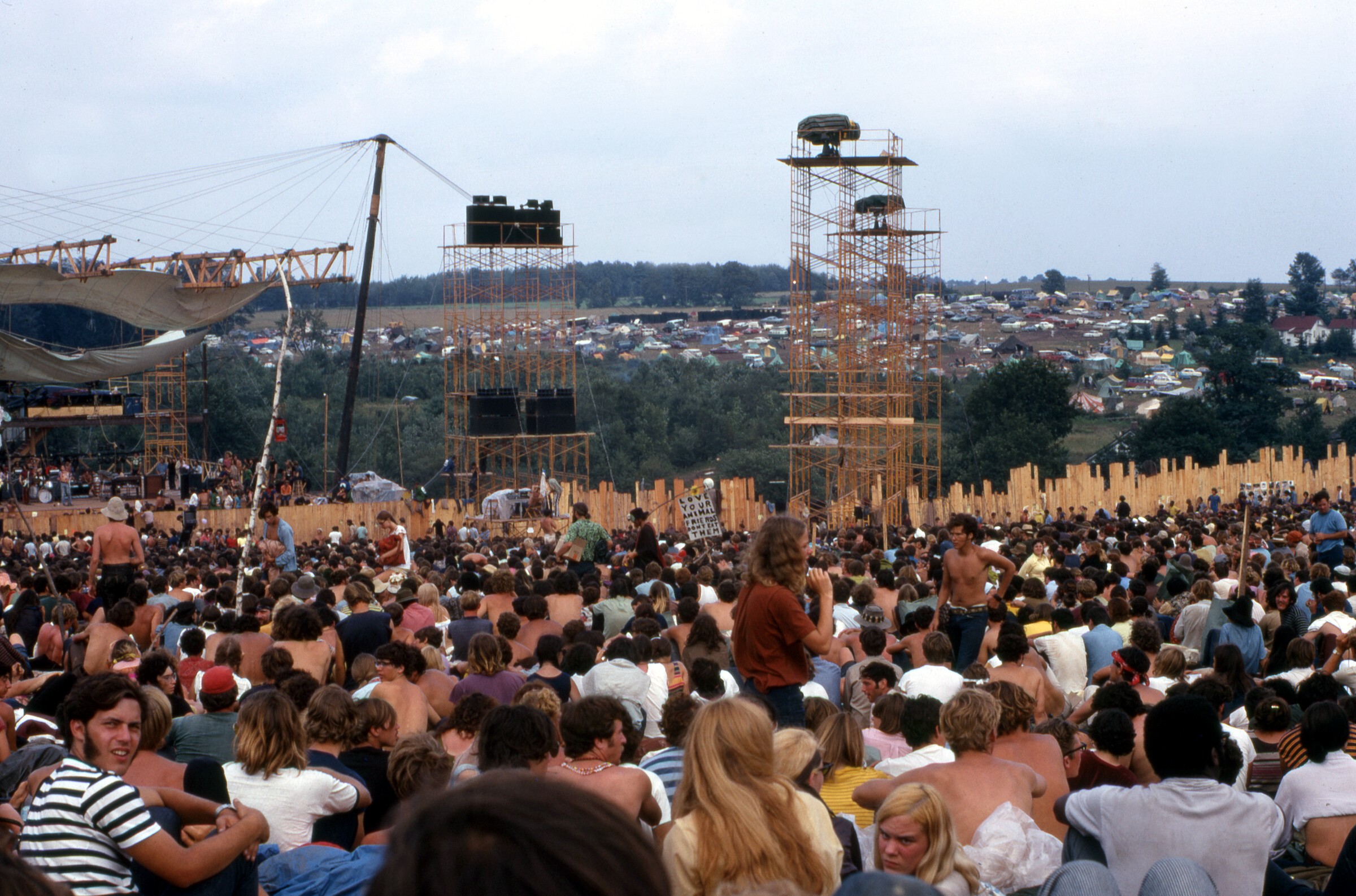 Picture taken on 17 August 1969 at the Woodstock Music and Art Fair. The person carrying the placard is Moonfire Lewis Beach Marvin III. Joe Cocker is performing on stage. CC BY-SA 4.0